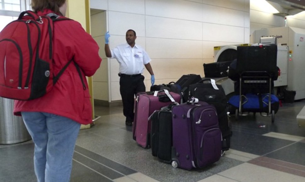 Oro uosto darbuotojas ruošia bagažą tikrinimui ir pakrovimui į lėktuvą