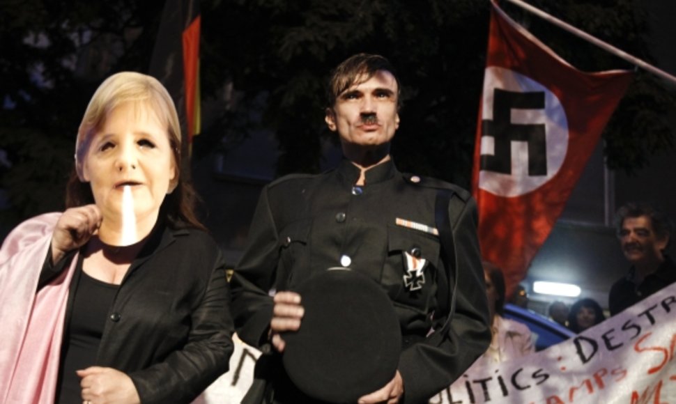 People role playing as Adolf Hitler (C) and German Chancellor Angela Merkel take part in a protest outside the German embassy in Athens October 6, 2011.