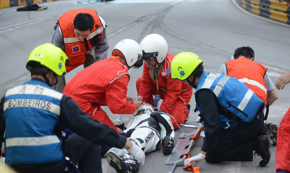 Luis Filipe de Sousa Carreira (C), competitor No. 33, from Portugal receives medial attention after a racing accident at Fisherman's Bend during the qualifying session of the Macao Motorcycle Grand Prix in Macao, south China, November 15, 2012. Portuguese rider Luis Carreira, who crashed in qualifyi