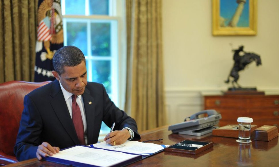Barackas Obama deda parašą kaire ranka