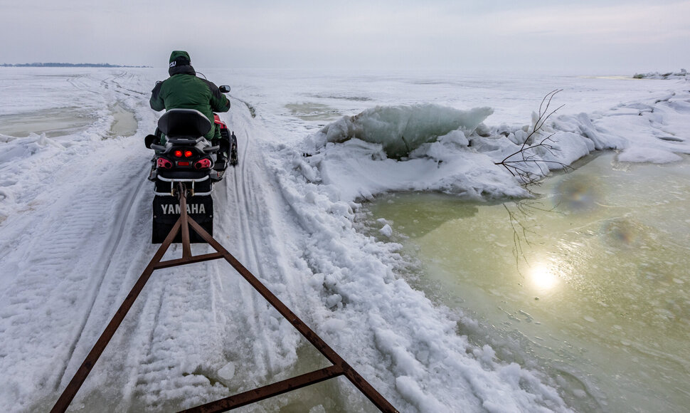 Vietiniai gyventojai sniego motociklais vežioja žvejus ir turistus lietuvi&scaron;kuoju Kur&scaron;ių marių Ledo keliu