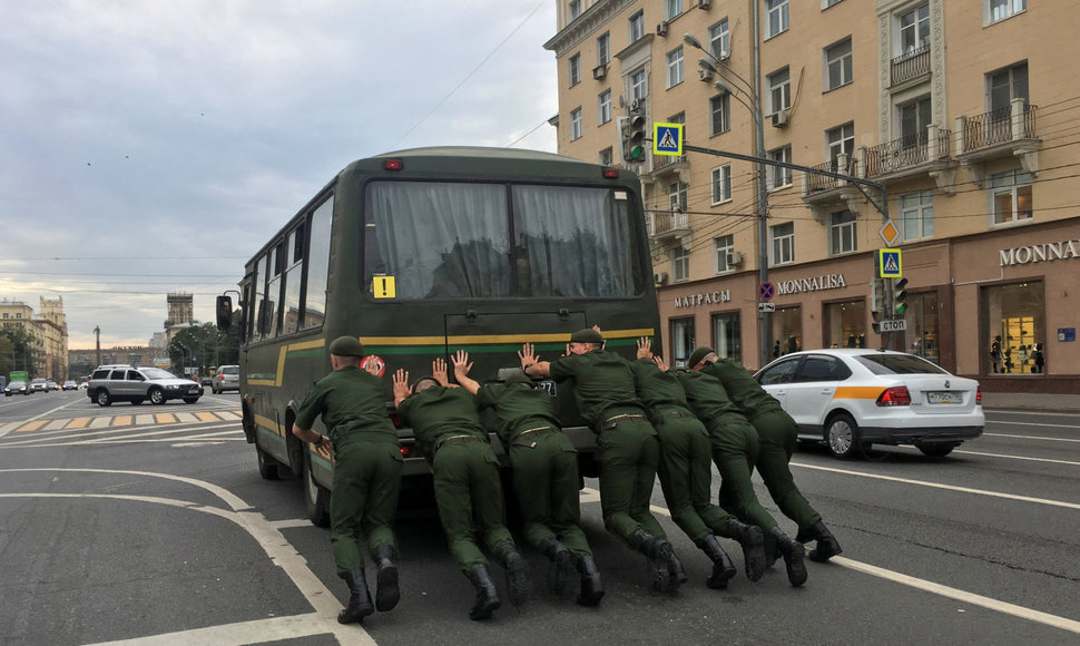 Rusų kariai stumia autobusą Maskvos gatvėje