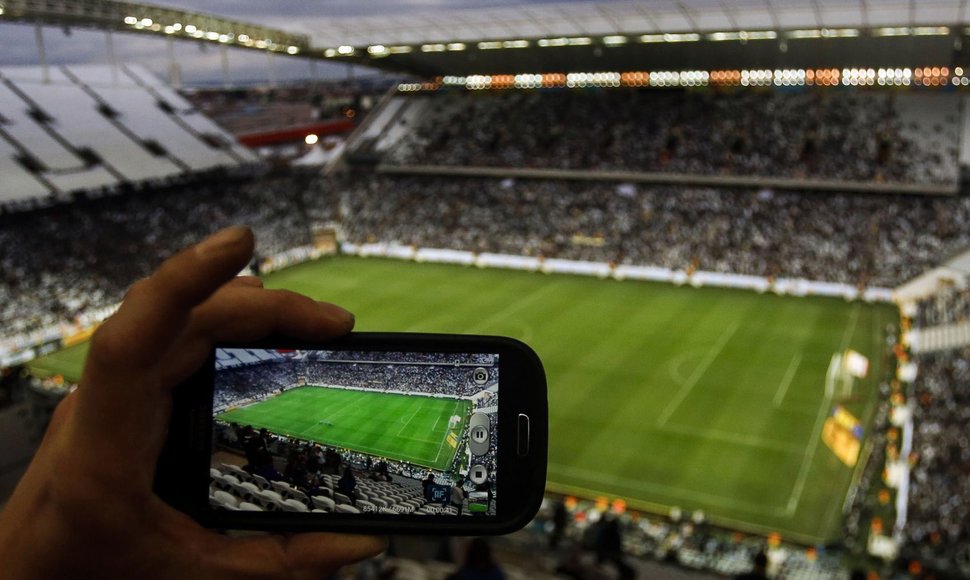 Išmaniuoju telefonu fotografuojamas futbolo stadionas