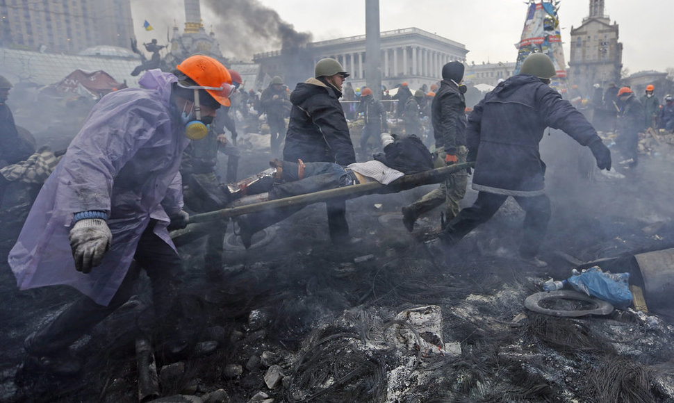 Anti-government protesters carry an injured man on a stretcher after clashes with riot police in the Independence Square in Kiev February 20, 2014. Ukrainian protesters hurling petrol bombs and paving stones drove riot police from the central square in Kiev on Thursday despite a "truce" which embatt