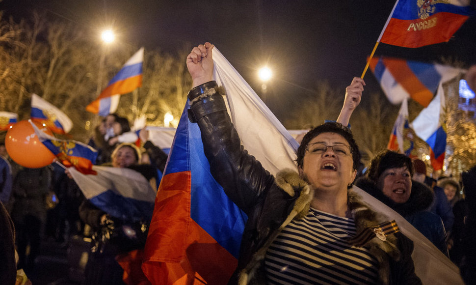 Pro-Russian people celebrate in the central square in Sevastopol, Ukraine, late Sunday, March 16, 2014. Russian flags fluttered above jubilant crowds Sunday after residents in Crimea voted overwhelmingly to secede from Ukraine and join Russia. The United States and Europe condemned the ballot as ill