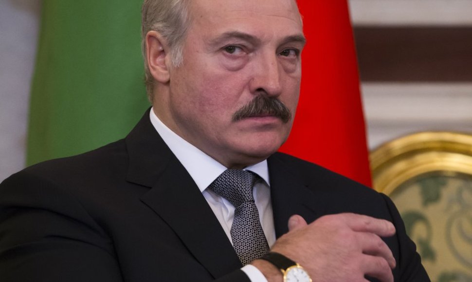 Belarus' President Alexander Lukashenko looks at the media as he listens to Russian President Vladimir Putin during their meeting in Moscow's Kremlin, Russia, Wednesday, Dec. 25, 2013. The two ex-Soviet neighbors signed agreements on military-technical cooperation and information security following 