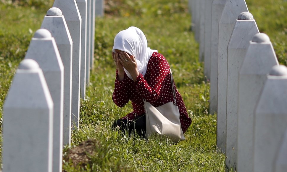 Moteris meldžiasi prie artimojo kapo Srebrenicos masakre. / Dado Ruvic / REUTERS