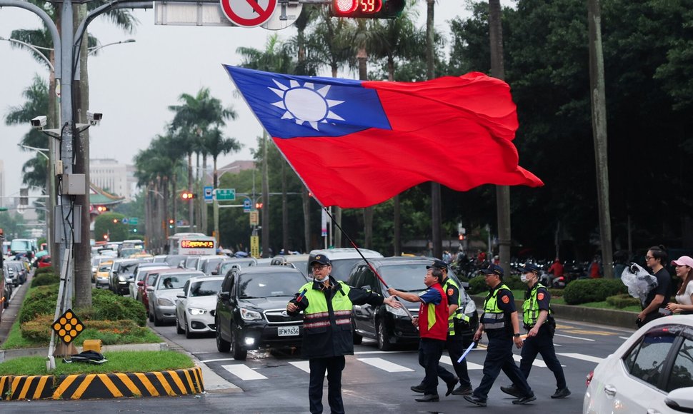 Vyras su Taivanio vėliava lydimas policijos Taipejyje. / Ann Wang / REUTERS/