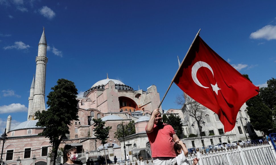 Vyras prie Hagia Sophia vilkioja Turkijos vėliavą. / MURAD SEZER / REUTERS