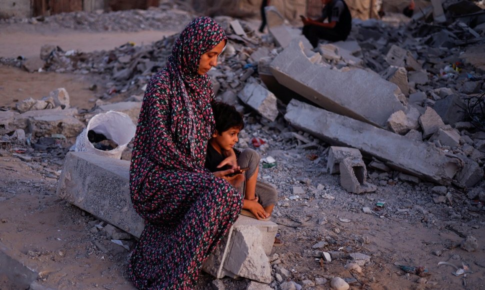 Palestiniečių studentai mokosi ant griuvėsių su telefonais. / Mohammed Salem / REUTERS