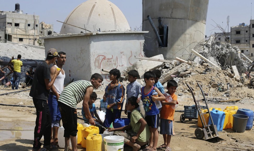 Palestiniečių vaikai renka vandenį per penkių dienų paliaubas Gazos juostoje. / Ibraheem Abu Mustafa / REUTERS