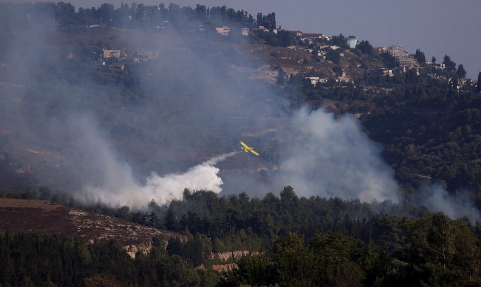 Gelbėjimo komandos gesina namo liepsnas Izraelyje po raketos išpuolio. / Jim Urquhart / REUTERS