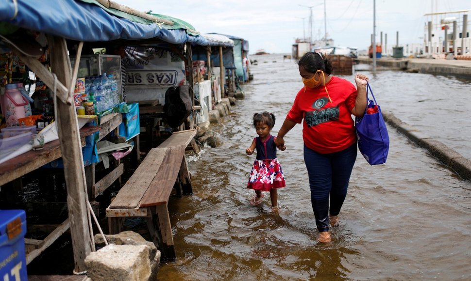 Evi su dukra perėjo per vandenį Kali Adem uoste. / WILLY KURNIAWAN / REUTERS