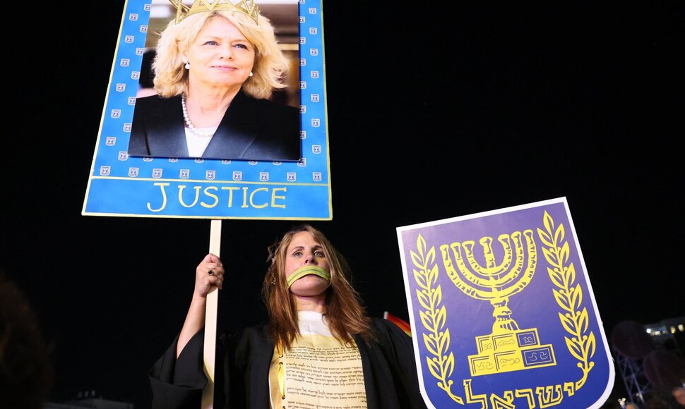 Demonstrantė laiko plakatą su Izraelio generalinės prokurorės atvaizdu / JACK GUEZ / AFP