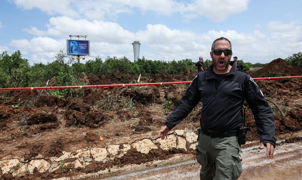 Izraelio policininkai tiria smūgio kraterį po husių raketos smūgio Ben Guriono oro uostui / Nir Elias / REUTERS
