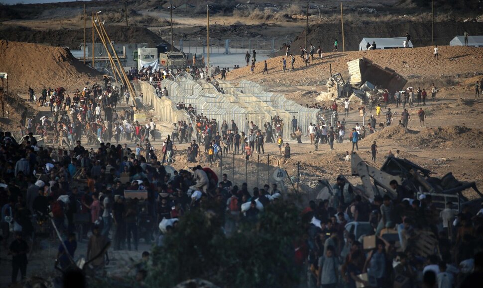 Palestiniečiai eina į humanitarinės pagalbos skirstymo punktus / EYAD BABA / AFP