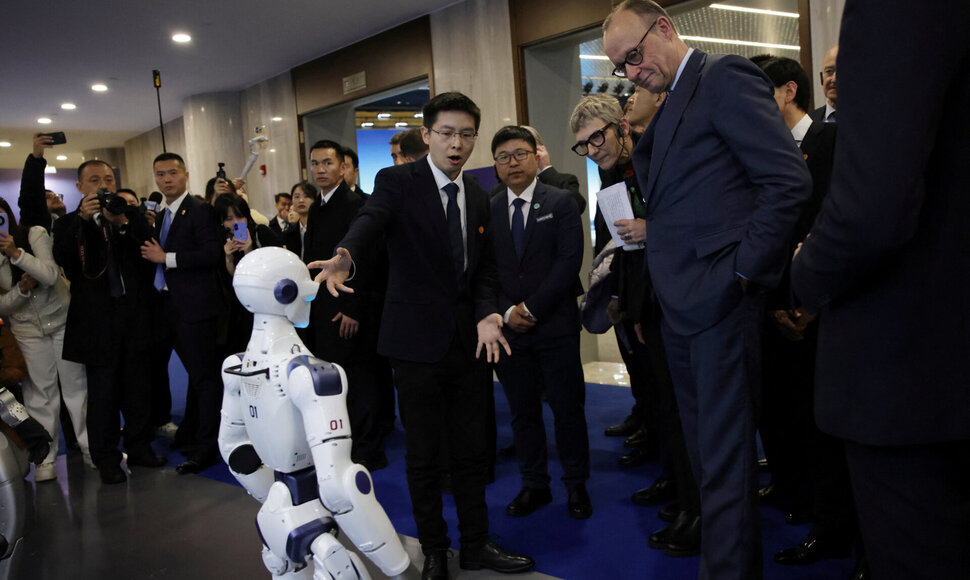 Friedrichas Merzas prie Kinijoje pagaminto roboto / Andres Martinez Casares / via REUTERS