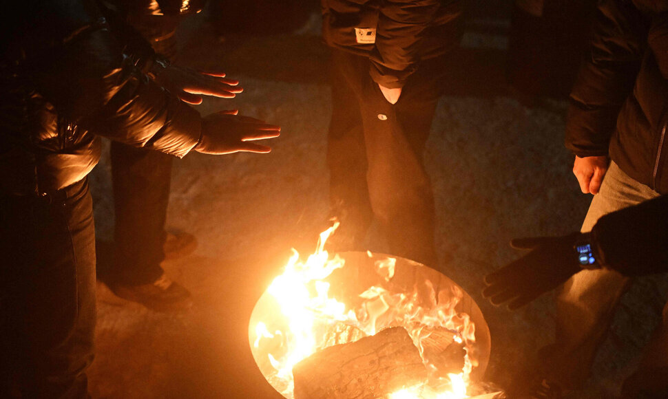 Kyjive žmonės šildosi prie laužo / SERGEI GAPON / AFP