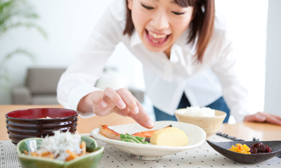 Mergina mėgaujasi japonų virtuvės patiekalais