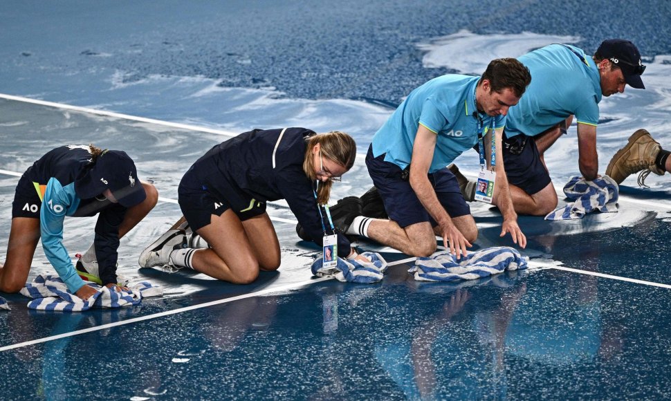 „Australia Open“ turnyre savanoriams teko rankšluosčiais sausinti aikštę.