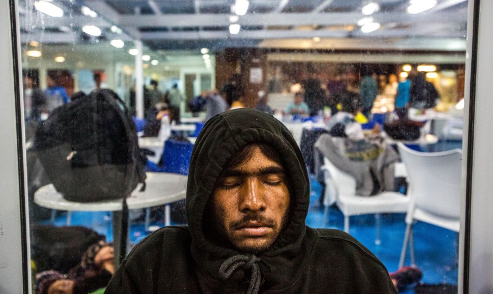 Migrantai miega kelte, plaukiančiame į Atėnus.