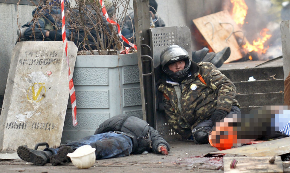 Vyras sėdi šalia dviejų žuvusių protestuotojų 