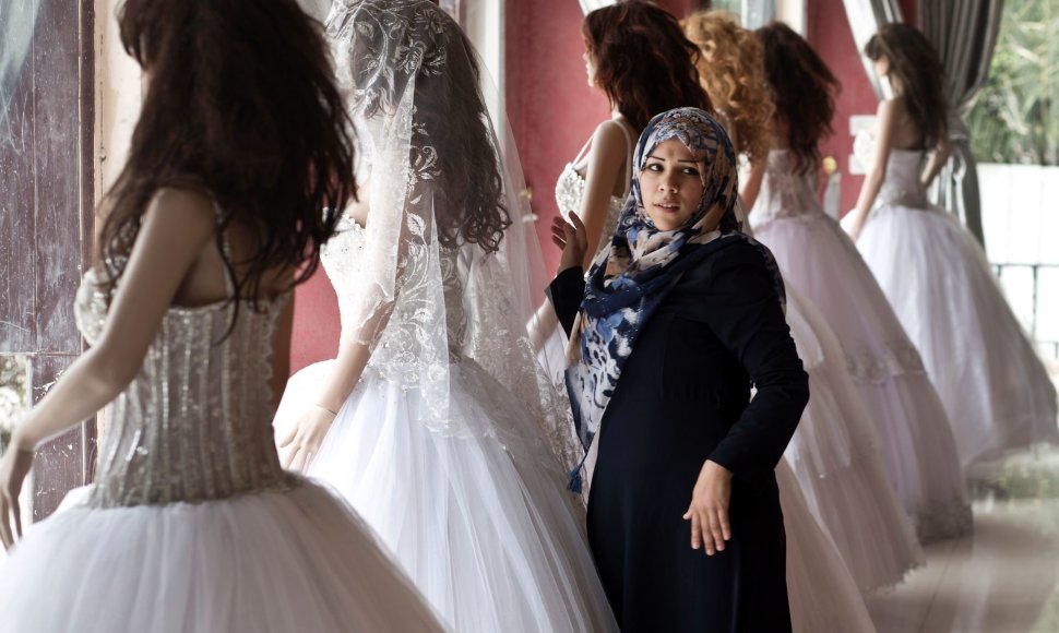 Mergina Gazoje apžiūri vestuvines sukneles