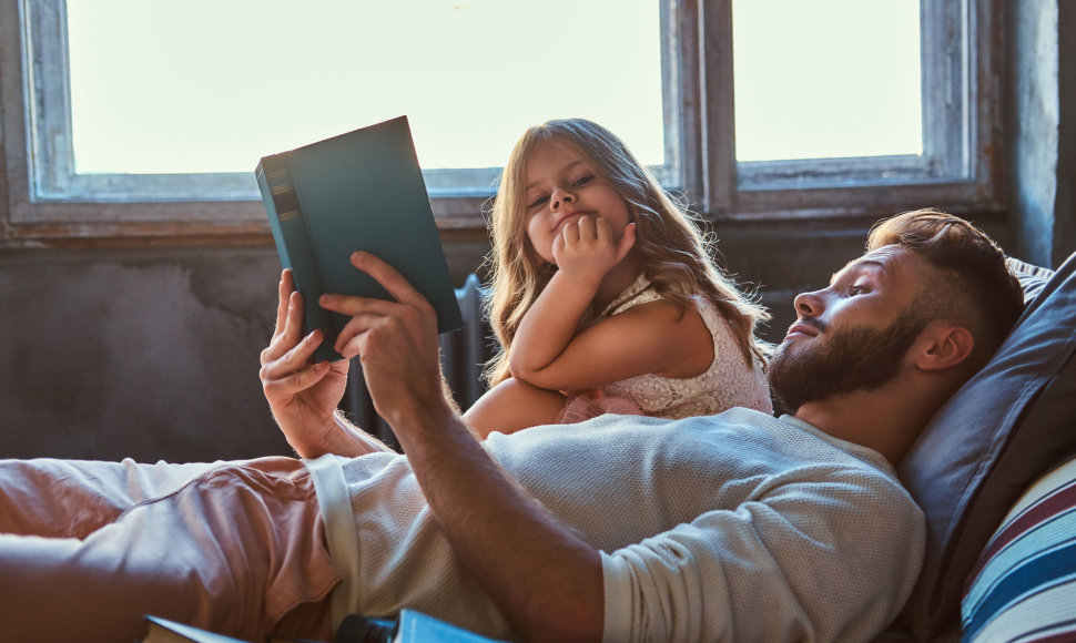 Tėtis skaito knygą dukrai