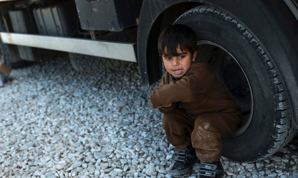 Migrantas vaikas prie sunkvežimio