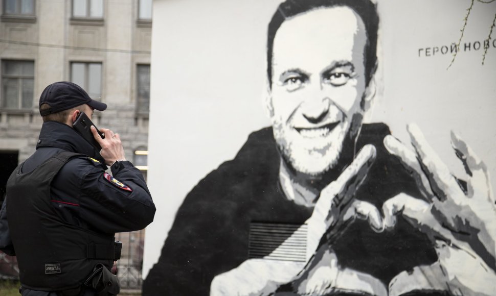 Pareigūnas prie Aleksejaus Navalno atvaizdo Sankt Peterburgas