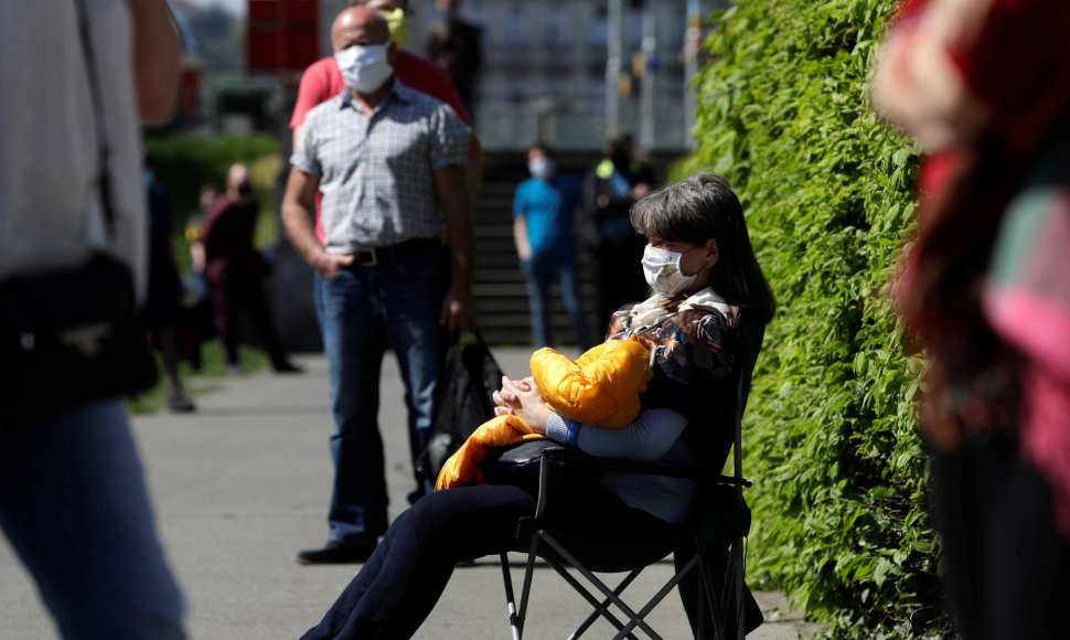 Prahoje moteris laukia eilėje, kad būtų patikrinta dėl koronaviruso