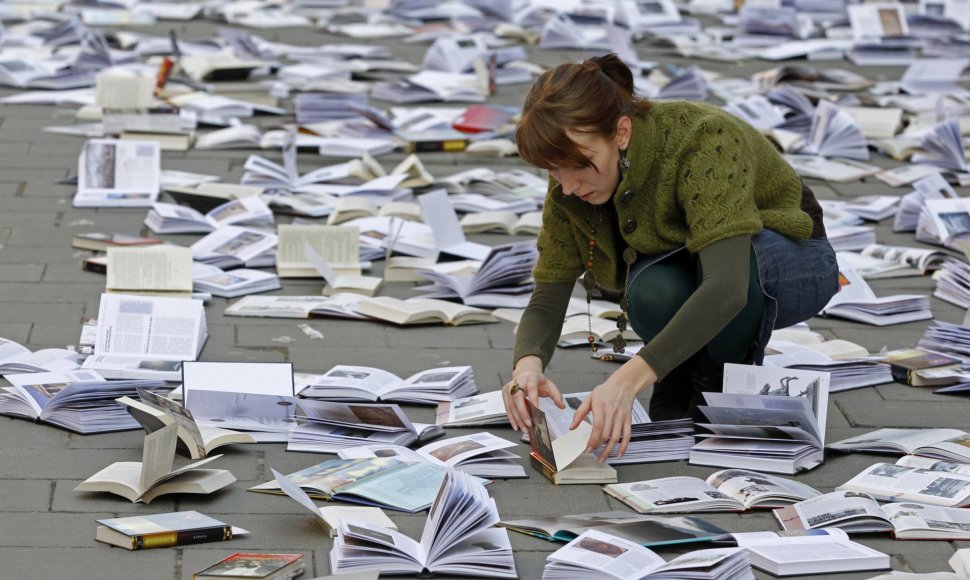 Moteris išdėlioja knygas renginiui skirtam pasaulinei knygos ir autorinių teisių dienai Bukarešte