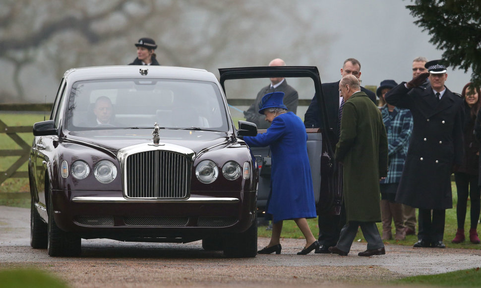 Karalienė Elizabeth II ir princas Philipas lipa į automobilį.