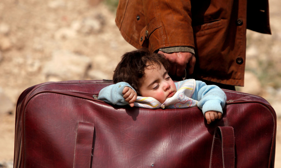 Sirija, 2018 kovo 15 d. Iš šalies bėgančių žmonių vaikas miega lagamine