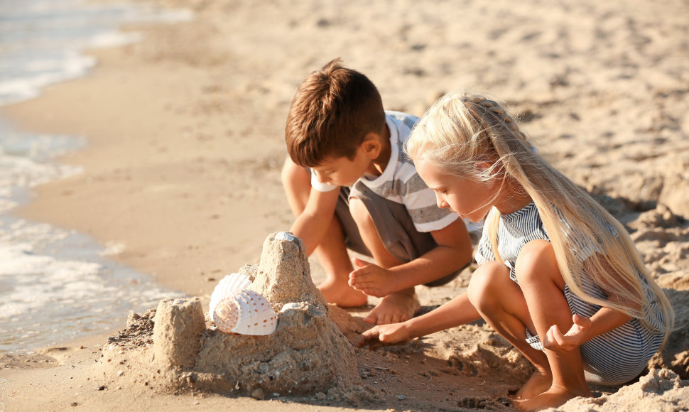 Vaikai žaidžia su smėliu