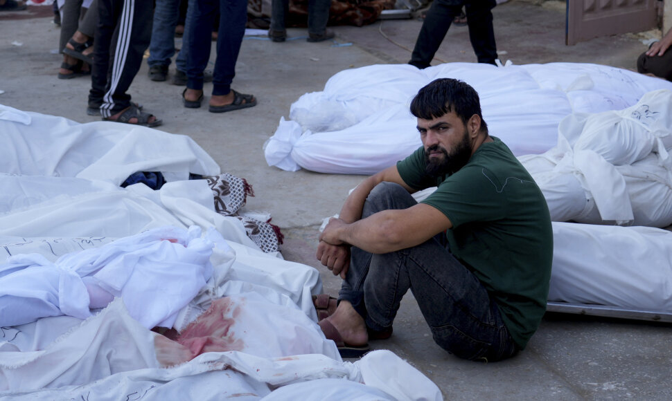 Palestinietis sėdi tarp žuvusiųjų kūnų Gazos ruože