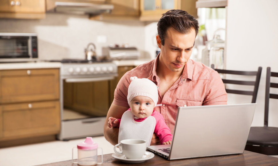 Tėtis su kūdikiu ir kompiuteriu