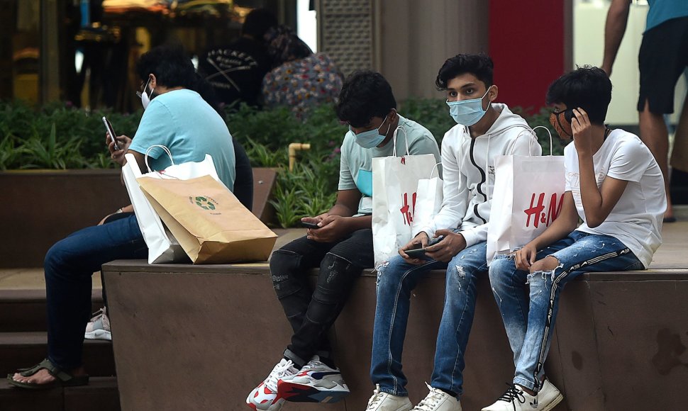 Jauni žmonės su kaukėmis Mumbajuje