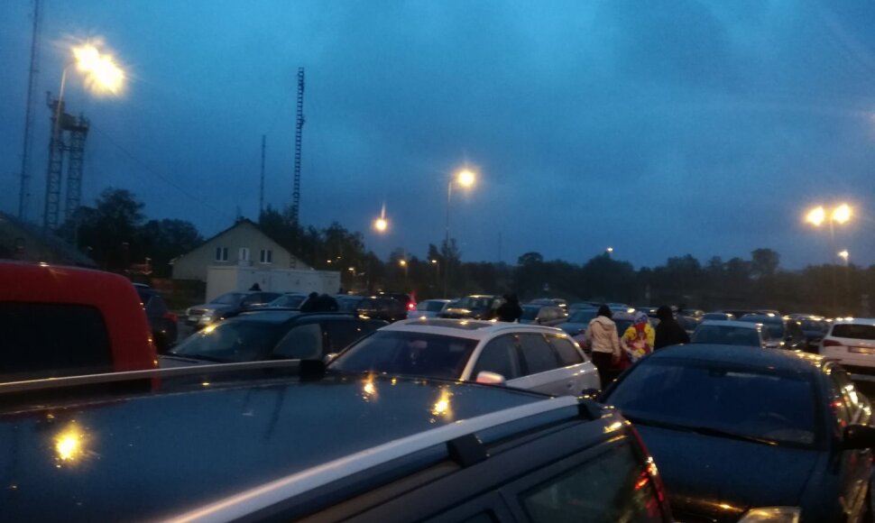 Audros į pajūrį plūstantys pažiūrėti žmonės.