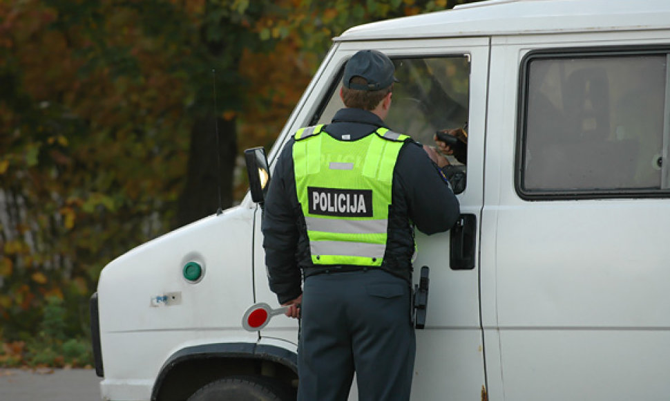 Policininkas tikrina vairuotojo dokumentus