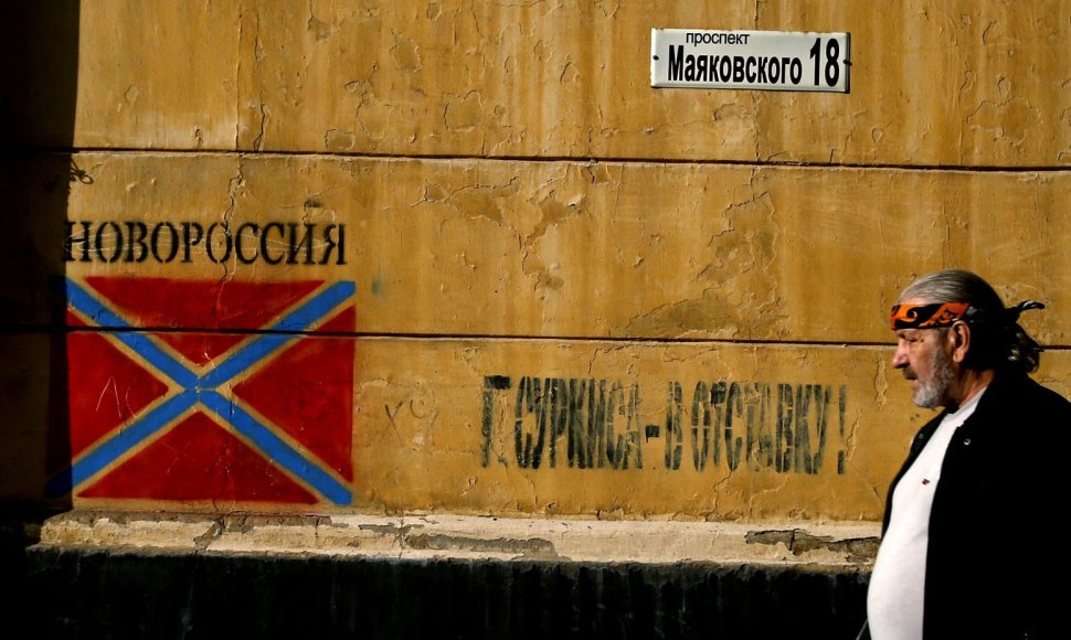 Vyras eina pro grafitį su apsišaukeliškos „Novorosijos“ vėliava Donecke
