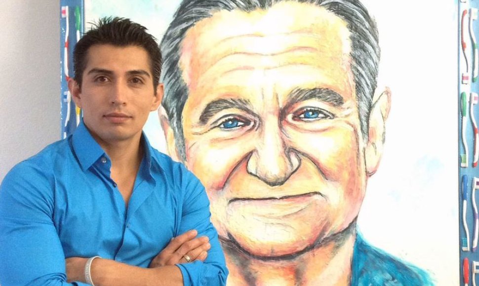 Menininkas Cristiamas Ramosas stovi prie savo kūrinio – Robino Williamso portreto 