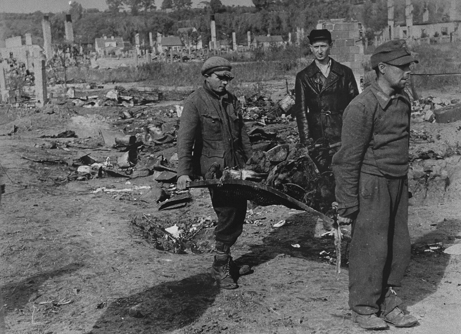 Prižiūrint sovietų policininkui, į masinę kapavietę i&scaron;ne&scaron;ami apanglėję Kauno geto žydų palaikai. Vyras pirmame plane &ndash; vokiečių karo belaisvis, už jo &ndash; Mo&scaron;ė Volber&scaron;teinas
