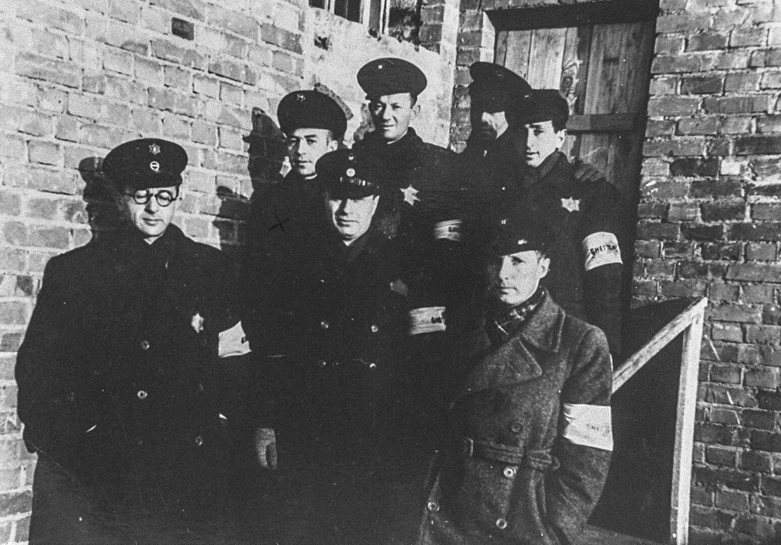Grupė žydų policininkų pozuoja prie geto kalėjimo