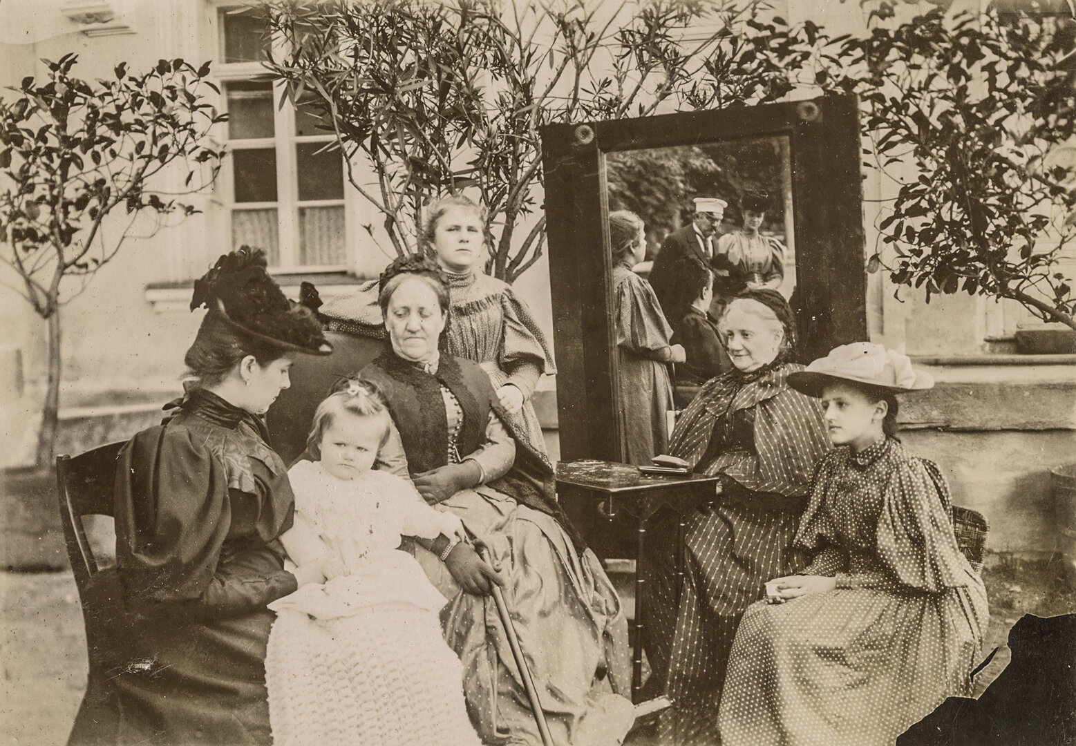 Prie veidrodžio. I&scaron; kairės sėdi: grafienė Sofija Kosakovska su dukra Jadvyga, grafo Stanislovo Kazimiero seserys Kotryna Lempicka ir Aleksandra Broel-Platerienė bei duktė i&scaron; antros santuokos Gabrielė; stovi Antanina Bower Saint Clair; veidrodyje atsispindi grafas ir grafienės sesuo Aleksandra Bower 